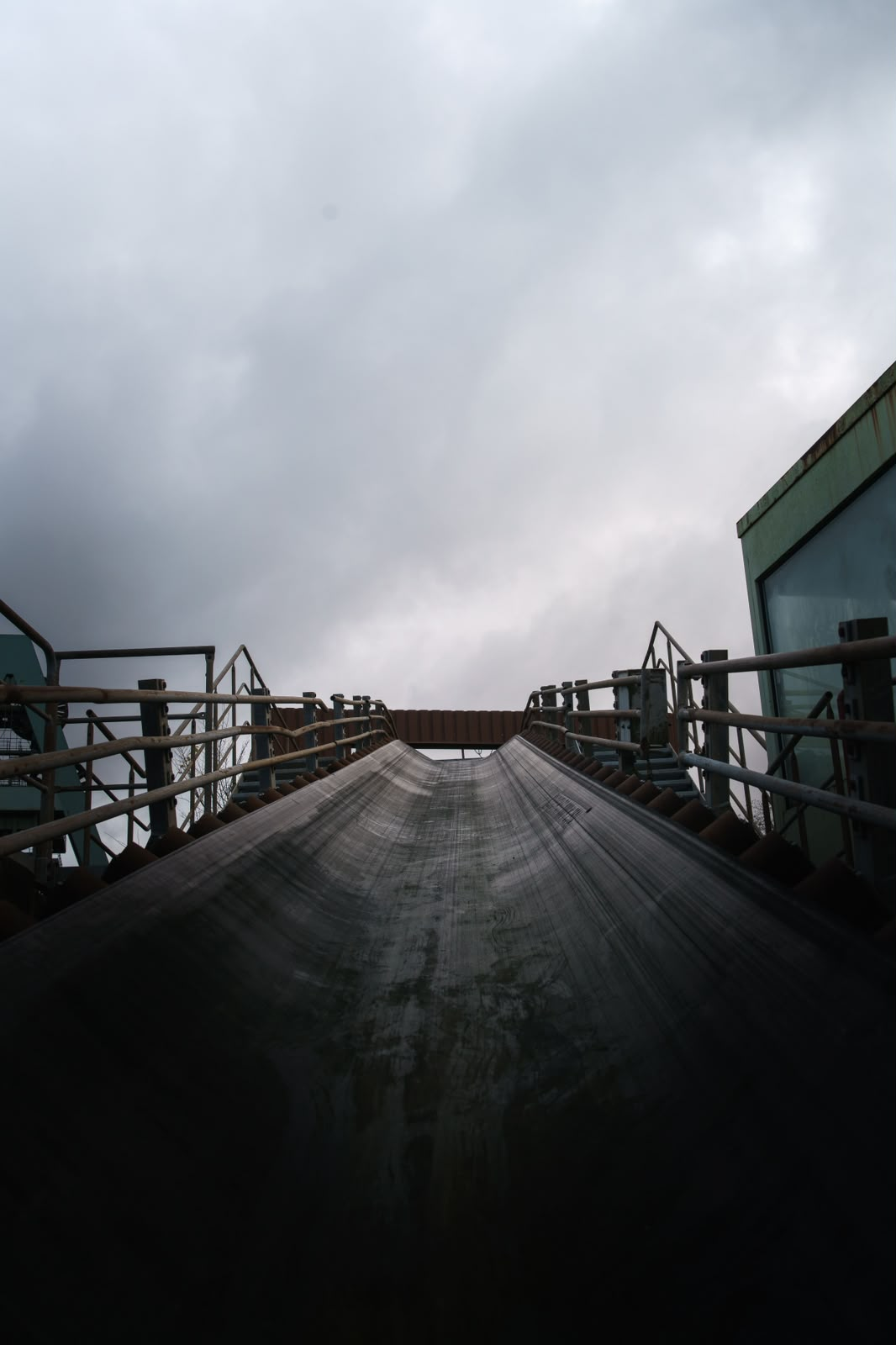 Vista em perspectiva de uma correia transportadora sob céu carregado